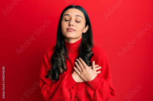 Young hispanic woman wearing casual clothes smiling with hands on chest, eyes closed with grateful gesture on face. health concept.