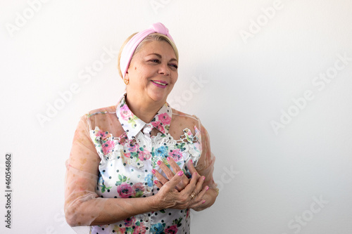 breast cancer, elderly woman with hands on chest smiling looking to the side, pink october