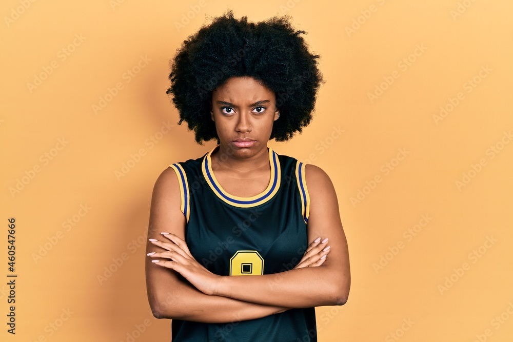 Young african american woman wearing basketball uniform skeptic and nervous, disapproving expression on face with crossed arms. negative person. Young african american woman wearing basketball uniform skeptic and nervous, disapproving expression on face with crossed arms. negative person.