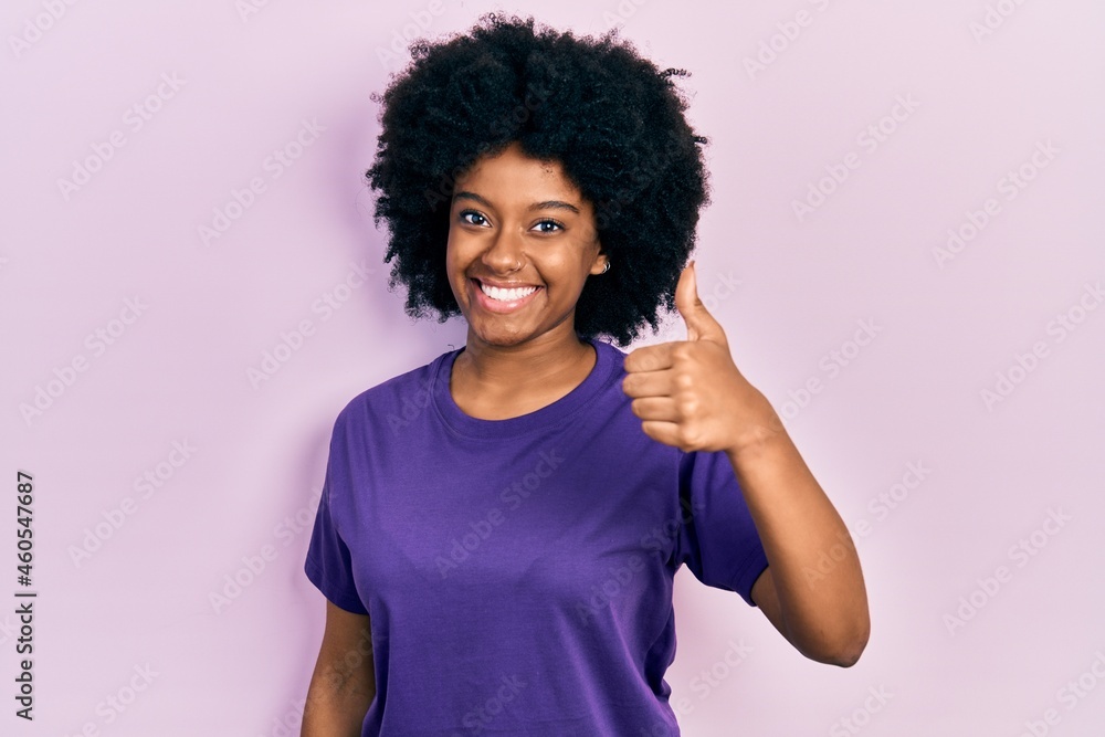 Young african american woman wearing casual clothes smiling happy and positive, thumb up doing excellent and approval sign