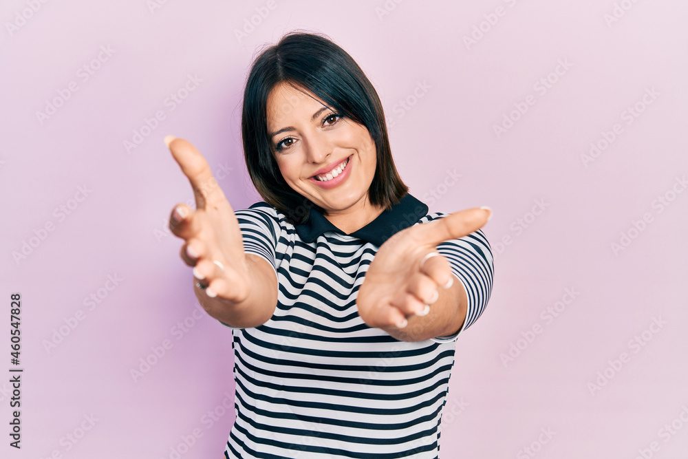 Young hispanic woman wearing casual clothes looking at the camera smiling with open arms for hug. cheerful expression embracing happiness. Young hispanic woman wearing casual clothes looking at the camera smiling with open arms for hug. cheerful expression embracing happiness.