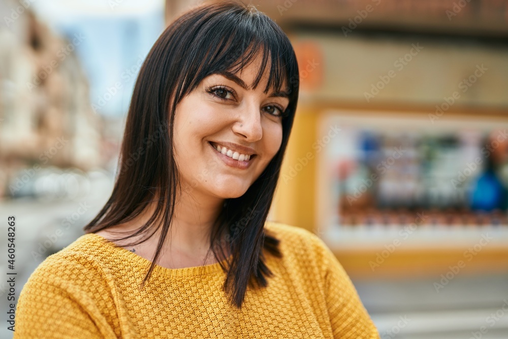 Young brunette woman smiling happy at the city