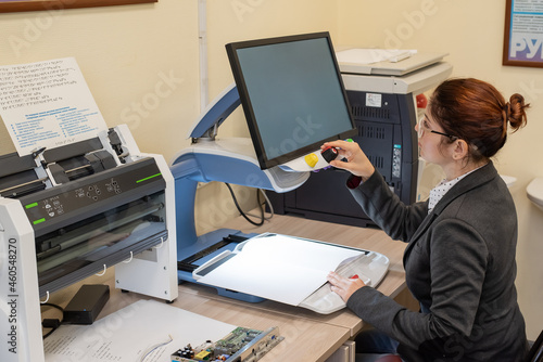 A visually impaired woman uses special reading equipment photo