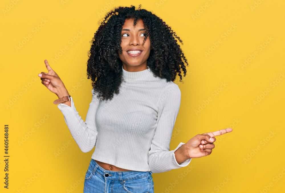 Young african american girl wearing casual clothes smiling confident pointing with fingers to different directions. copy space for advertisement Young african american girl wearing casual clothes smiling confident pointing with fingers to different directions. copy space for advertisement