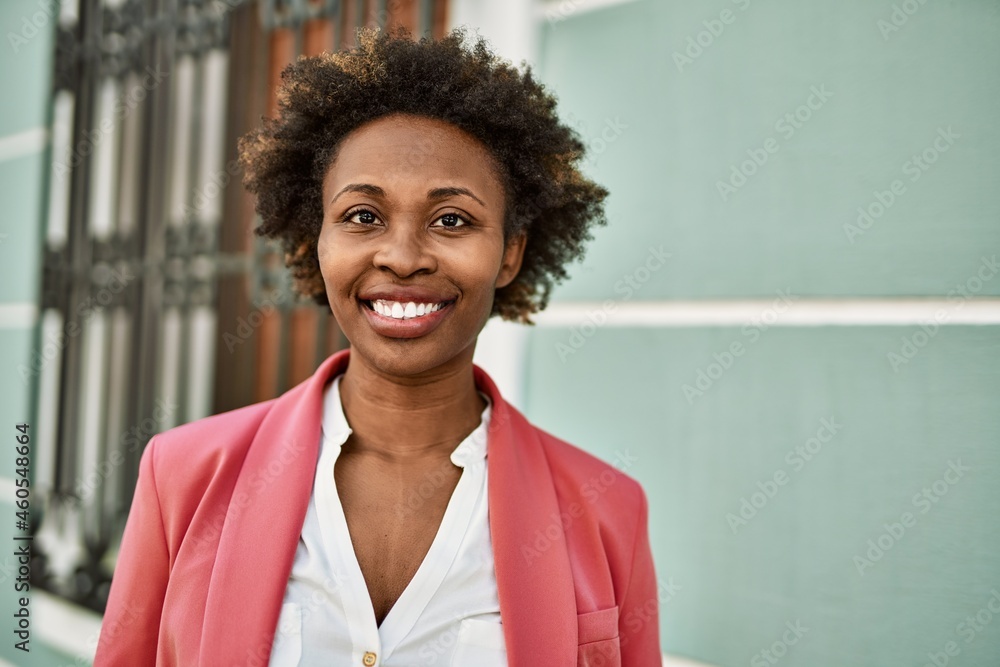 Beautiful business african american woman with afro hair smiling happy and confident outdoors at the city Beautiful business african american woman with afro hair smiling happy and confident outdoors at the city