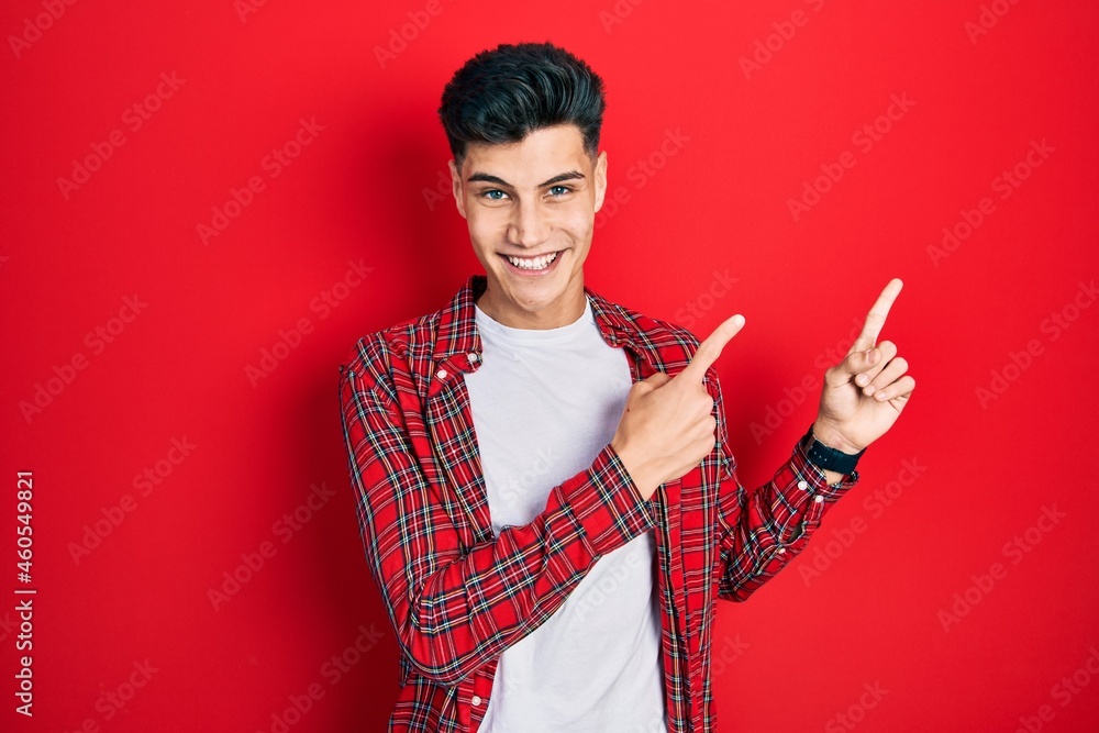 Young hispanic man wearing casual clothes smiling and looking at the camera pointing with two hands and fingers to the side. Young hispanic man wearing casual clothes smiling and looking at the camera pointing with two hands and fingers to the side.