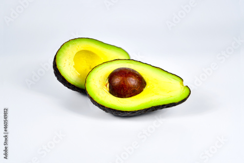 Fresh avocado cut in half with seed  isolated on white background.