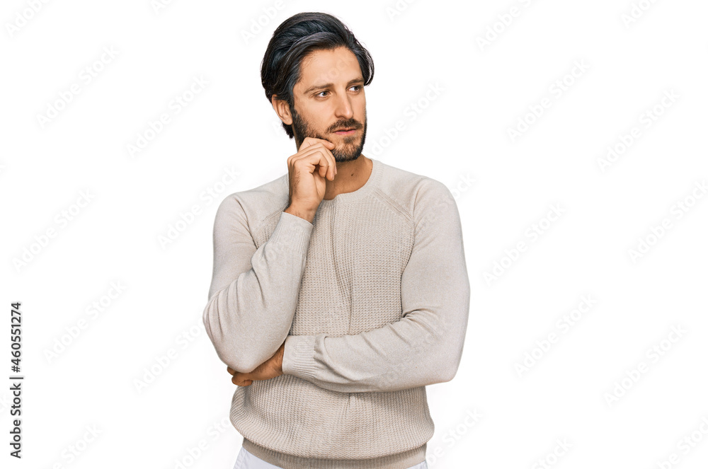 Young hispanic man wearing casual clothes serious face thinking about question with hand on chin, thoughtful about confusing idea Young hispanic man wearing casual clothes serious face thinking about question with hand on chin, thoughtful about confusing idea