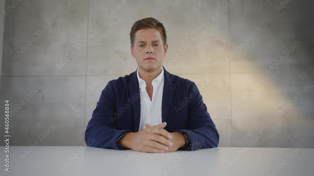 Min adult Caucasian man sitting at table with serious face expression and listening. Online job interview. Min adult Caucasian man sitting at table with serious face expression and listening. Online job interview.