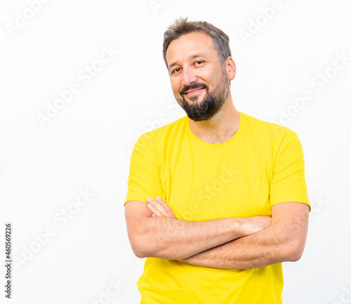 One positive man with yellow shirt portrait against wall