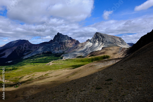 Mountain landscape photography, looking up to a pass with blue sky and clouds