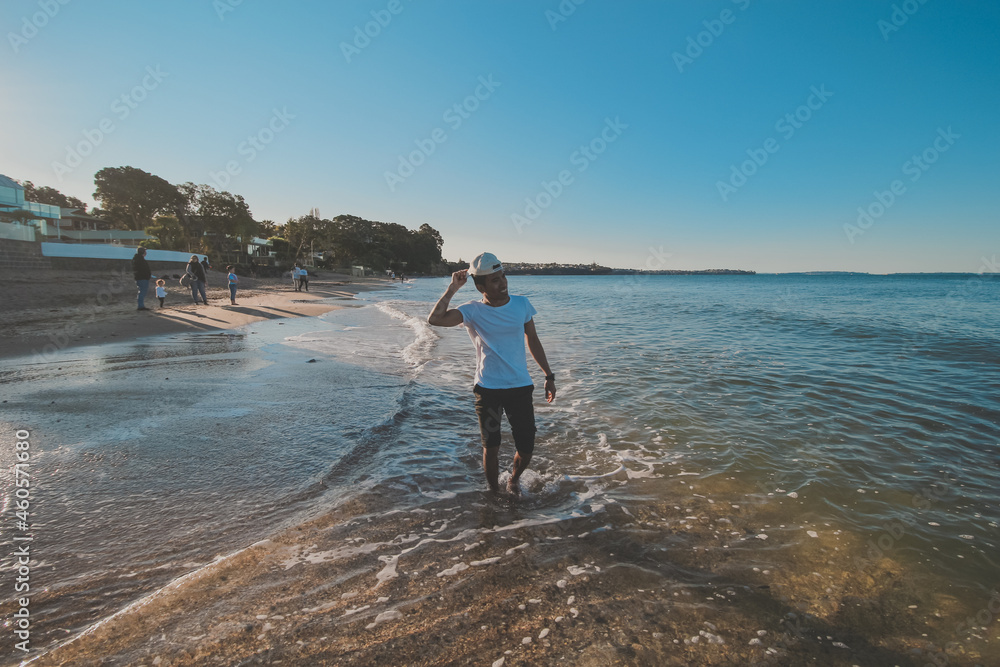 Asian man taking a photo shoot at campbells bay beach, Auckland, New