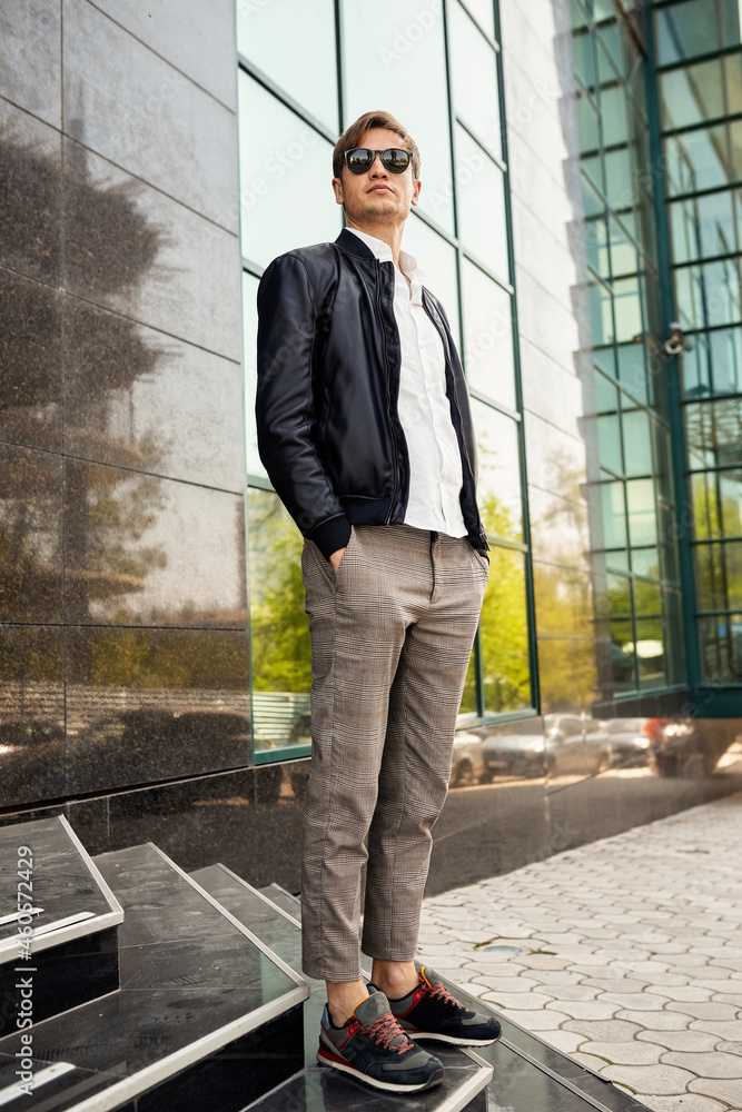 Full length image of a handsome young man posing near business centre, wearing casual outfit. Full length image of a handsome young man posing near business centre, wearing casual outfit.