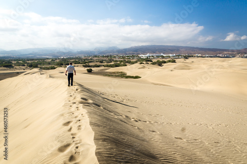 Blue sky and sand dunes with footprints.