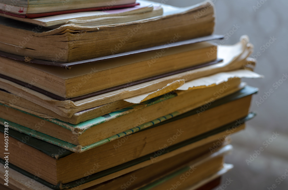 Fototapeta premium A stack of old books that have been read out. Textbooks and technical literature in close-up. Inside the room. Selective focus.
