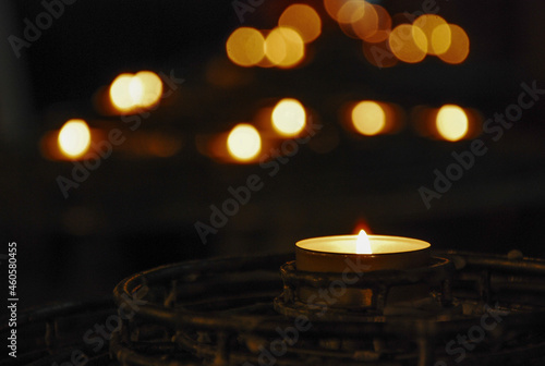 Burning candle with vintage bronze candlestick with dark background