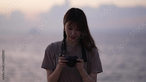 夕暮れに写真を撮る女性