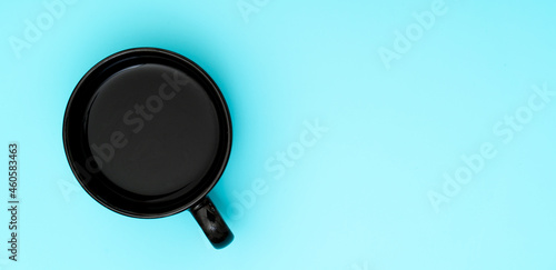 Top view, flat lay of black coffee cup on background blue.
