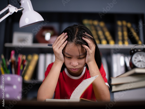 girl school student feeling headache or fatigue doing homework at home. Exhausted depressed sick teenager studying alone worried about difficult education problems concept.