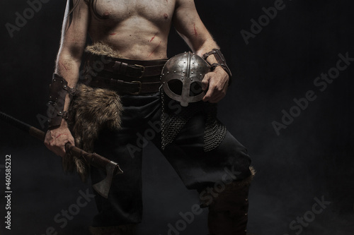 Close up viking warrior in full with ax on dark background