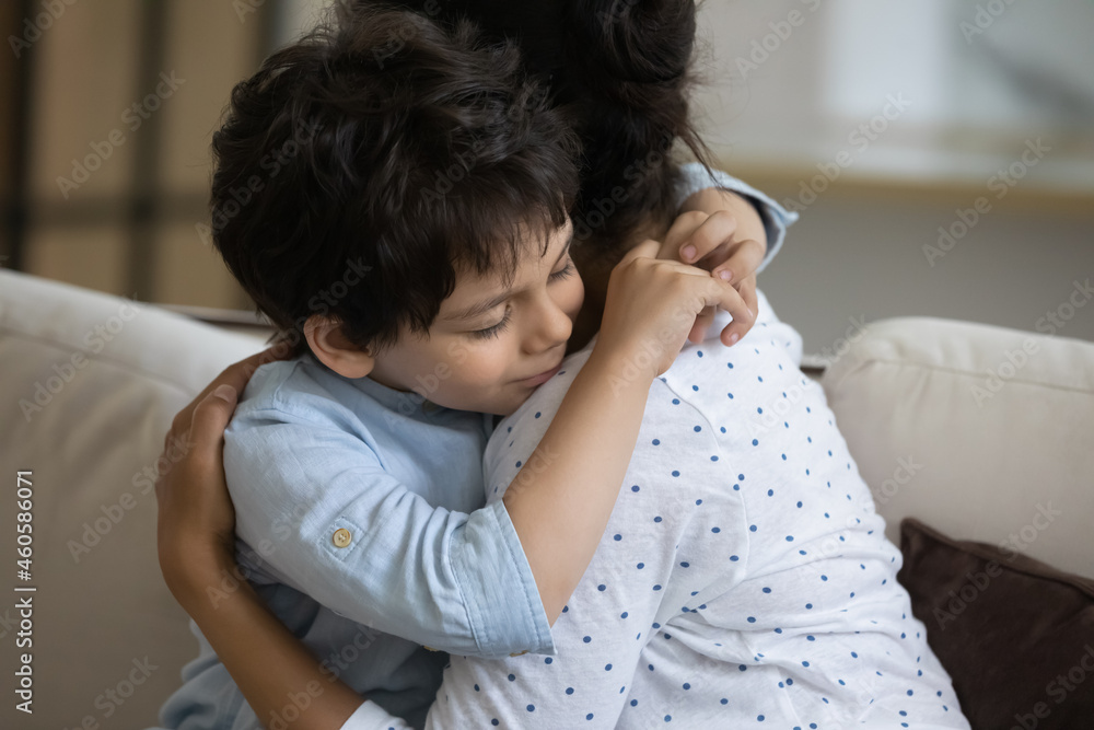 Adorable little kid son cuddling affectionate loving young indian mother, missing after long separation. Happy two generations asian ethnicity family showing tender feelings at home, family relations. - obrazy, fototapety, plakaty 
