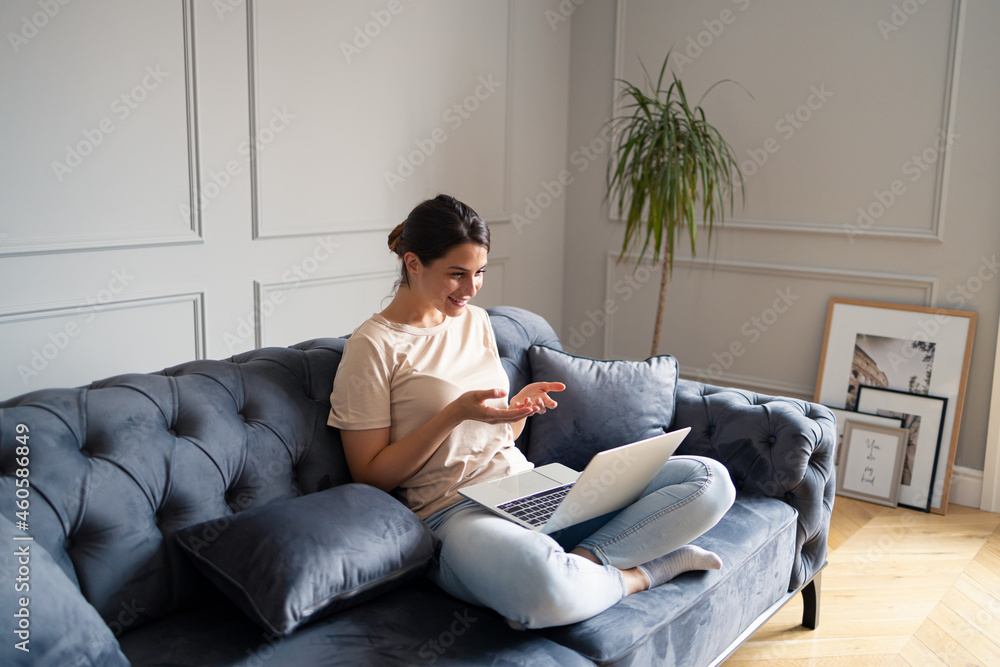 Obraz premium Happy woman having a video call over laptop at home.
