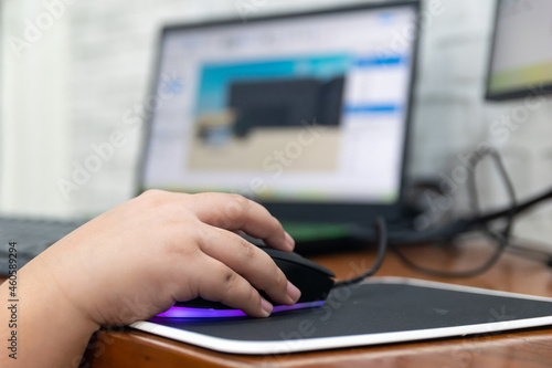 Children enjoying computer games while holding a computer mouse