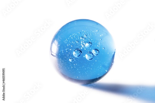 blue glass ball with bubbles against white background