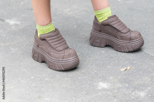 September 21, 2021: model wears brown wedge shoes and acid green stockings