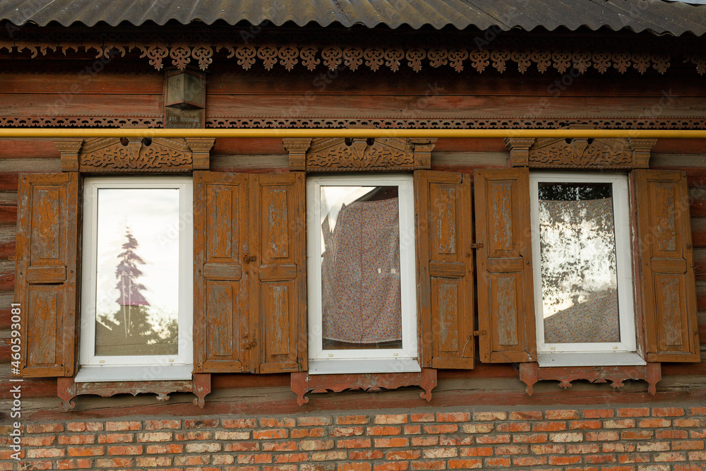 The beautiful old windows with beautifully designed platbands window on an old wooden house in the city of Tula
