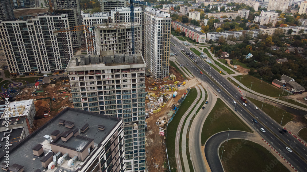 Construction of modern multi-storey buildings. Construction of a new city block. Buildings under construction and tower cranes. Aerial photography in cloudy weather. Construction of modern multi-storey buildings. Construction of a new city block. Buildings under construction and tower cranes. Aerial photography in cloudy weather.
