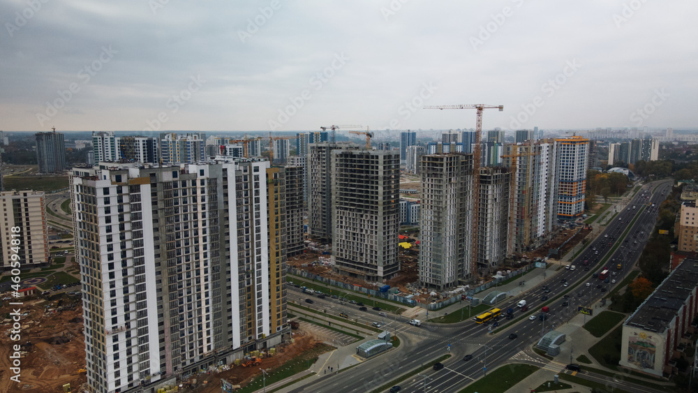 Construction of modern multi-storey buildings. Construction of a new city block. Buildings under construction and tower cranes. Aerial photography in cloudy weather. Construction of modern multi-storey buildings. Construction of a new city block. Buildings under construction and tower cranes. Aerial photography in cloudy weather.