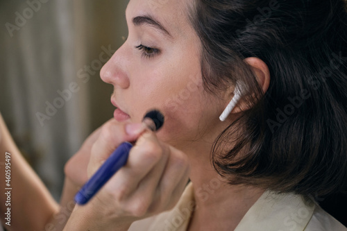 Female professional model at makeup before studio photo shooting