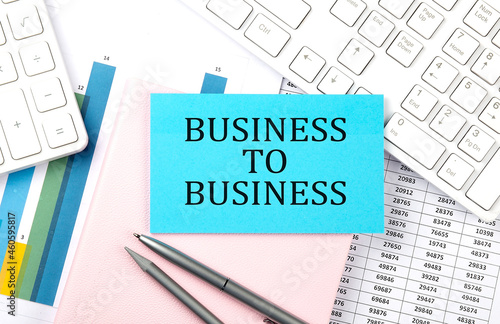 BUSINESS TO BUSINESS text on blue sticker on chart with calculator and keyboard,Business concept