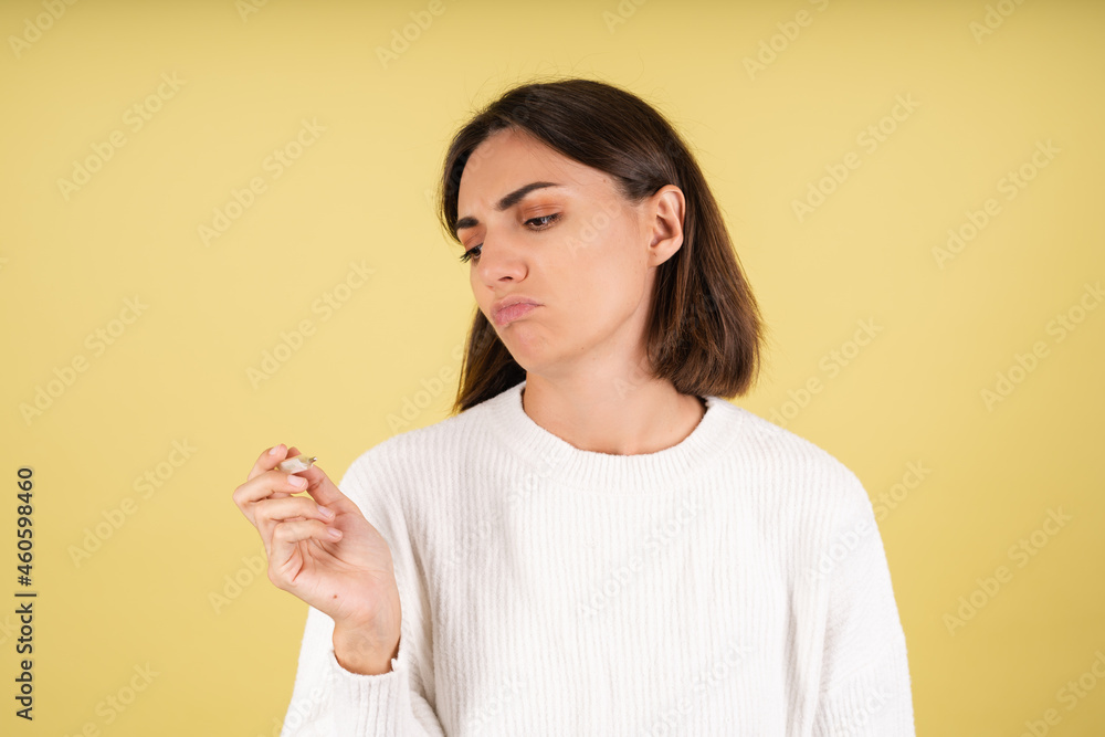 Young woman in white warm sweater holding thermometer unhappy disappointed don't like being sick Young woman in white warm sweater holding thermometer unhappy disappointed don't like being sick