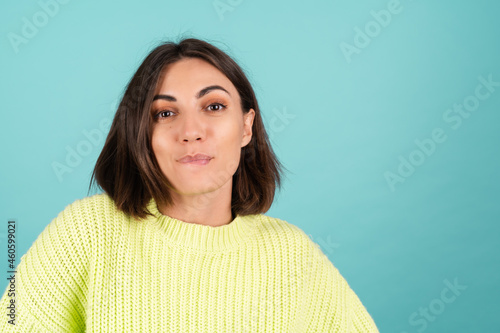Young woman in light green sweater cute smiling shy look to camera biting lip flirting
