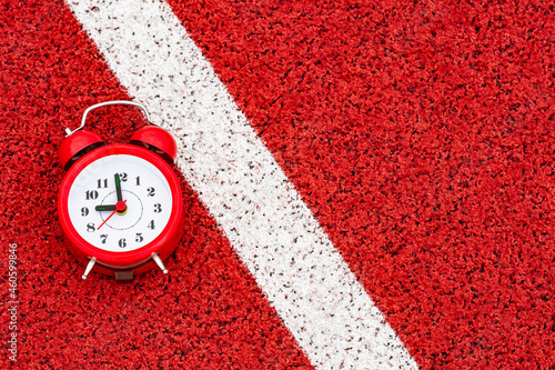 Alarm clock on the start line in sports stadium photo