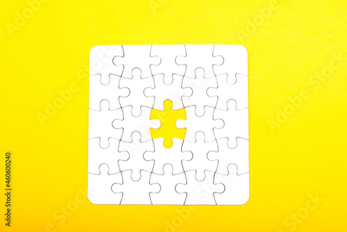 white jigsaw puzzle pieces isolated on a yellow background