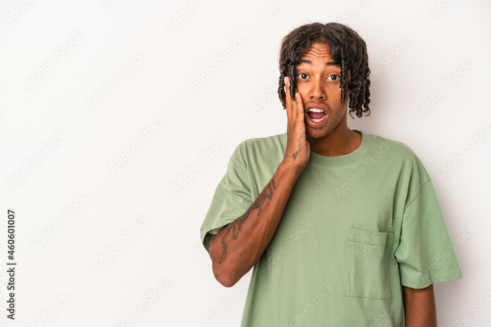 Young african american man isolated on white background shouts loud, keeps eyes opened and hands tense.