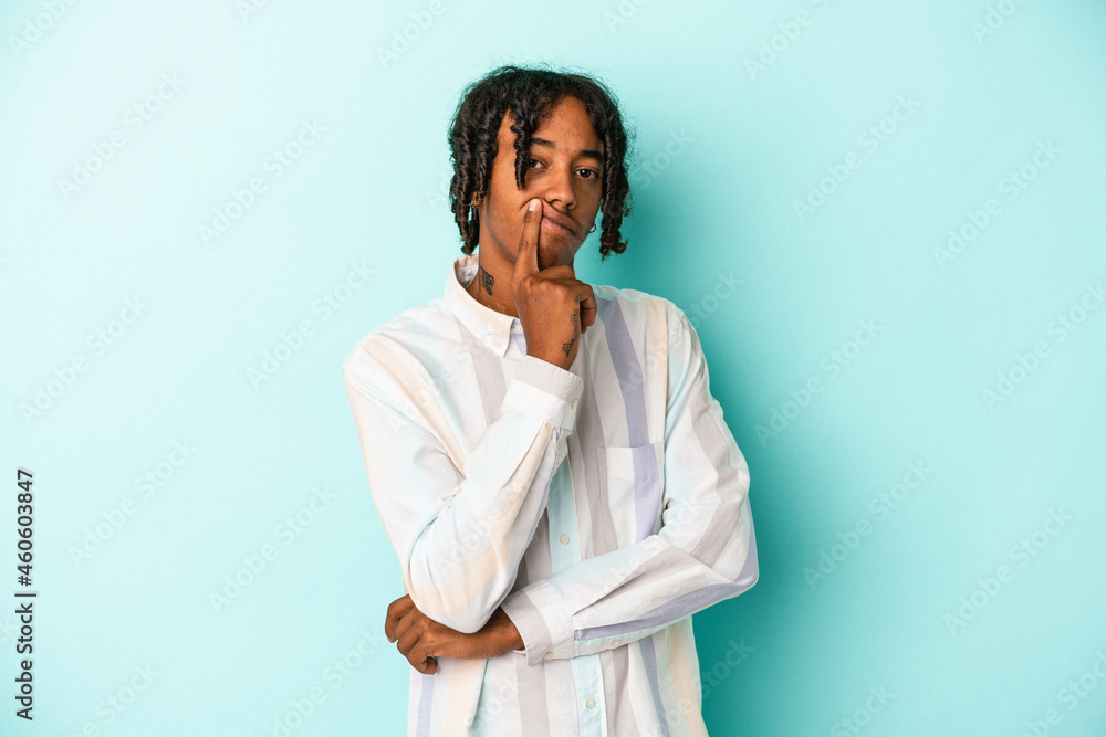 Young african american man isolated on blue background unhappy looking in camera with sarcastic expression.