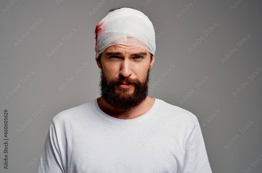 Man bandaged head and hand blood light background Man bandaged head and hand blood light background