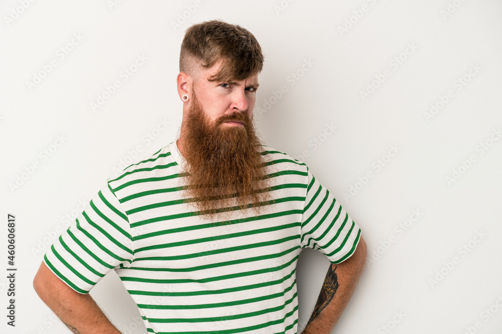 Obraz premium Young caucasian ginger man with long beard isolated on white background frowning face in displeasure, keeps arms folded.