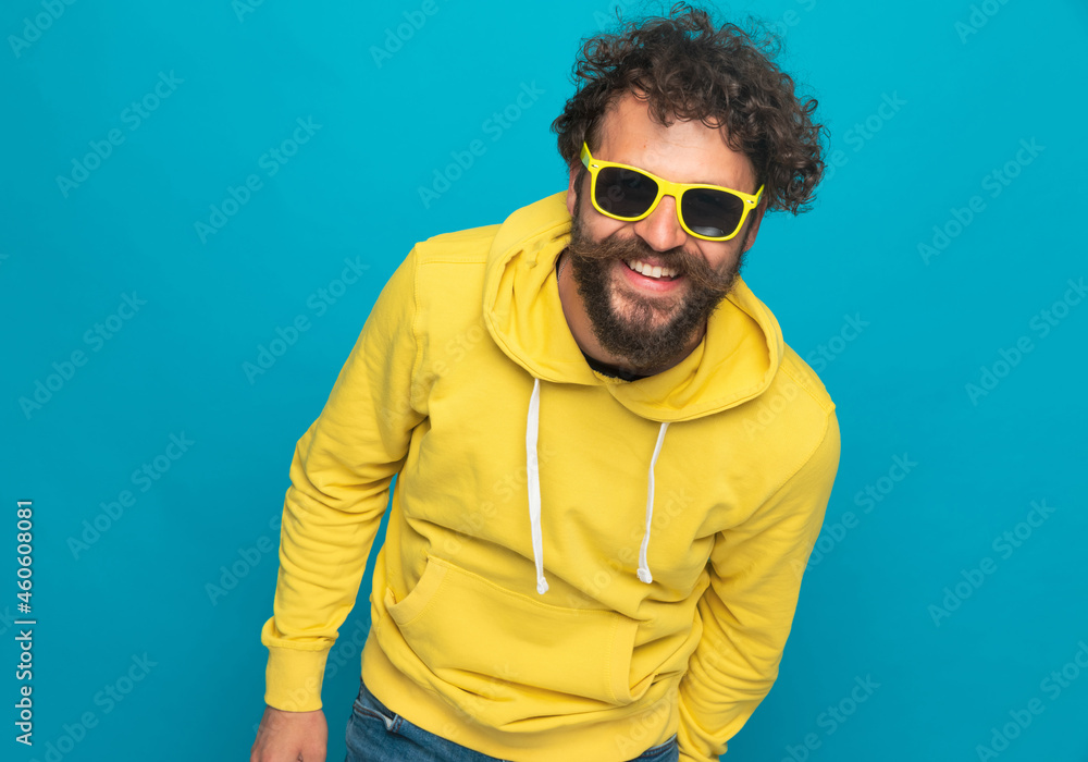 Obraz premium smiling curly hair guy with yellow hoodie laughing and having fun