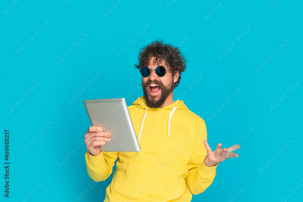 happy unshaved guy holding tab, making a hand gesture and laughing happy unshaved guy holding tab, making a hand gesture and laughing