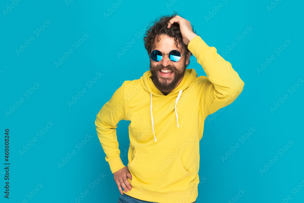 happy cool guy with curly hair and moustache holding hand on head happy cool guy with curly hair and moustache holding hand on head