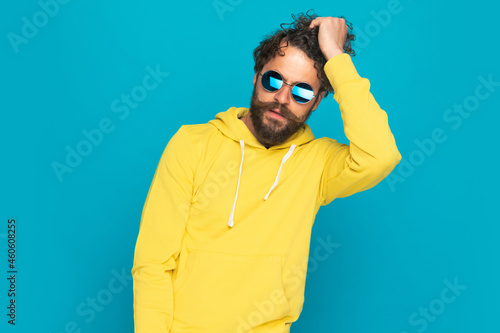 cool handsome man in yellow shirt getting fingers through hair