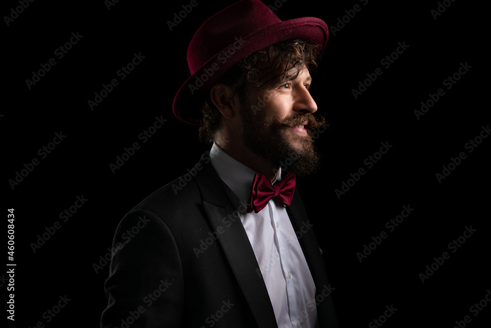 businessman looking away and smiling, wearing a burgundy hat