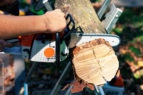 hands holding a chainsaw. A  a chainsaw in hand.