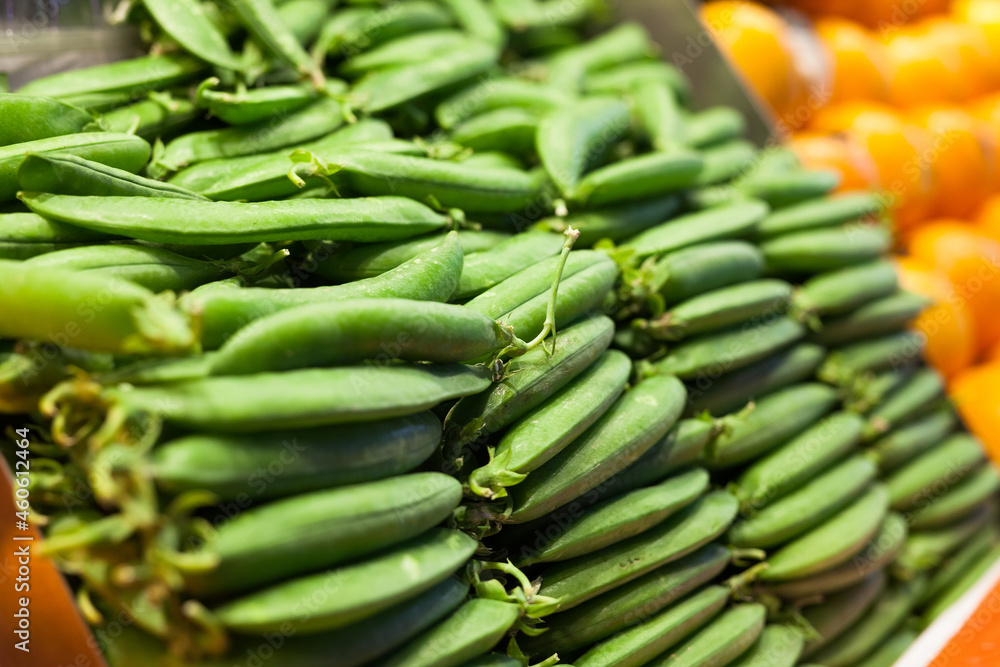 green fava beans in pods on counter in market green fava beans in pods on counter in market
