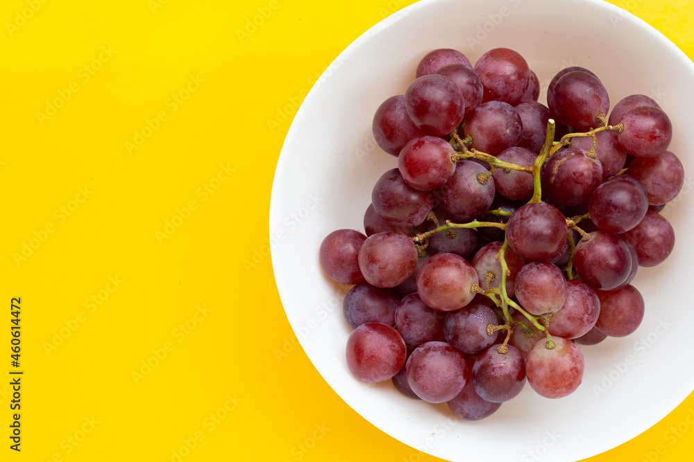 Fresh grape in white bowl on yellow background. Fresh grape in white bowl on yellow background.